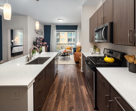 a kitchen with white counter tops and wooden floors